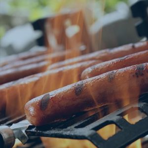 Hot dogs on fiery grill